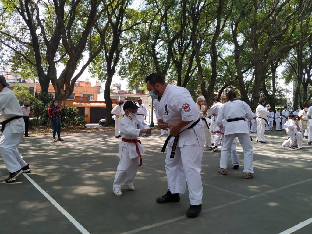 Instructor corrige la postura de un alumno infantil